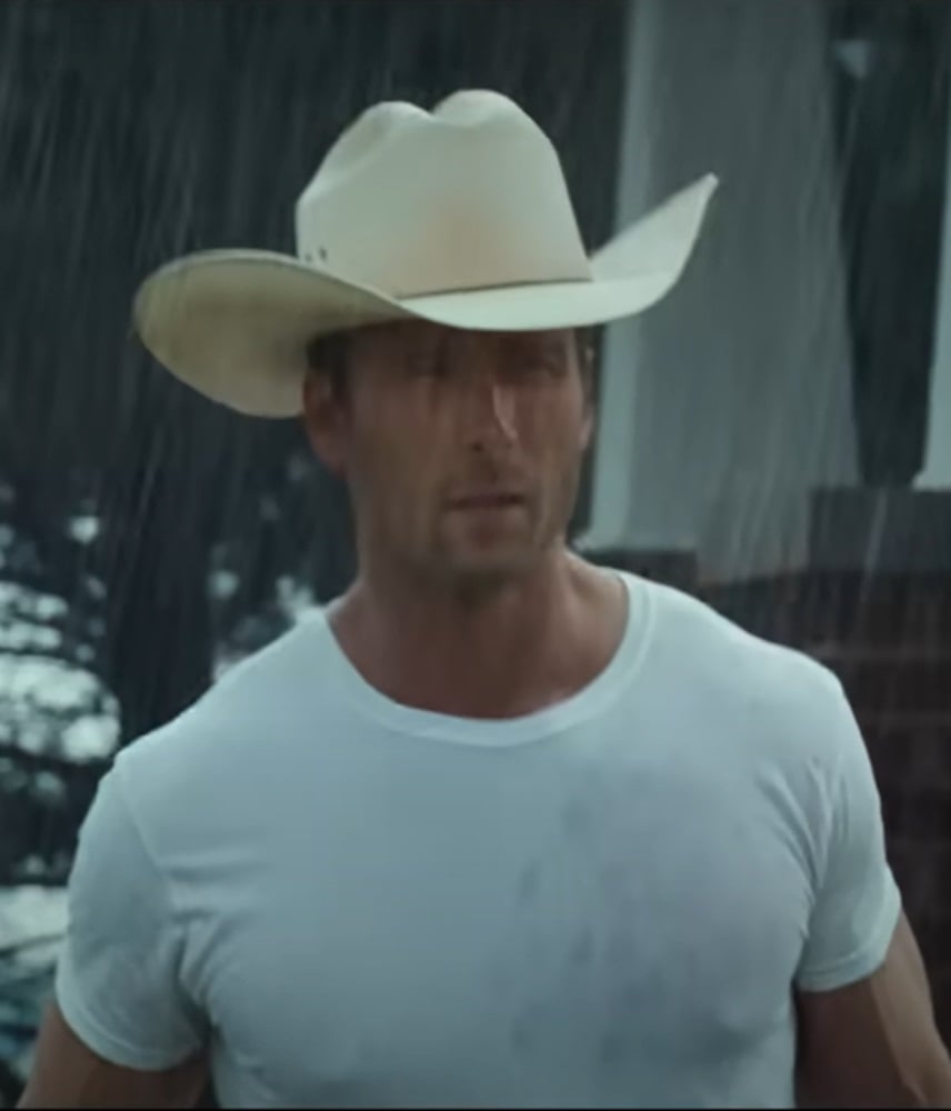 Glen Powell as Tyler Owens in the rain in Twisters.